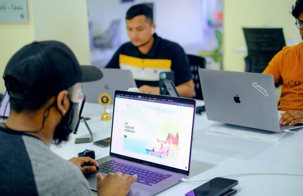 Business colleagues collaborating in an office setting with laptops and electronics.